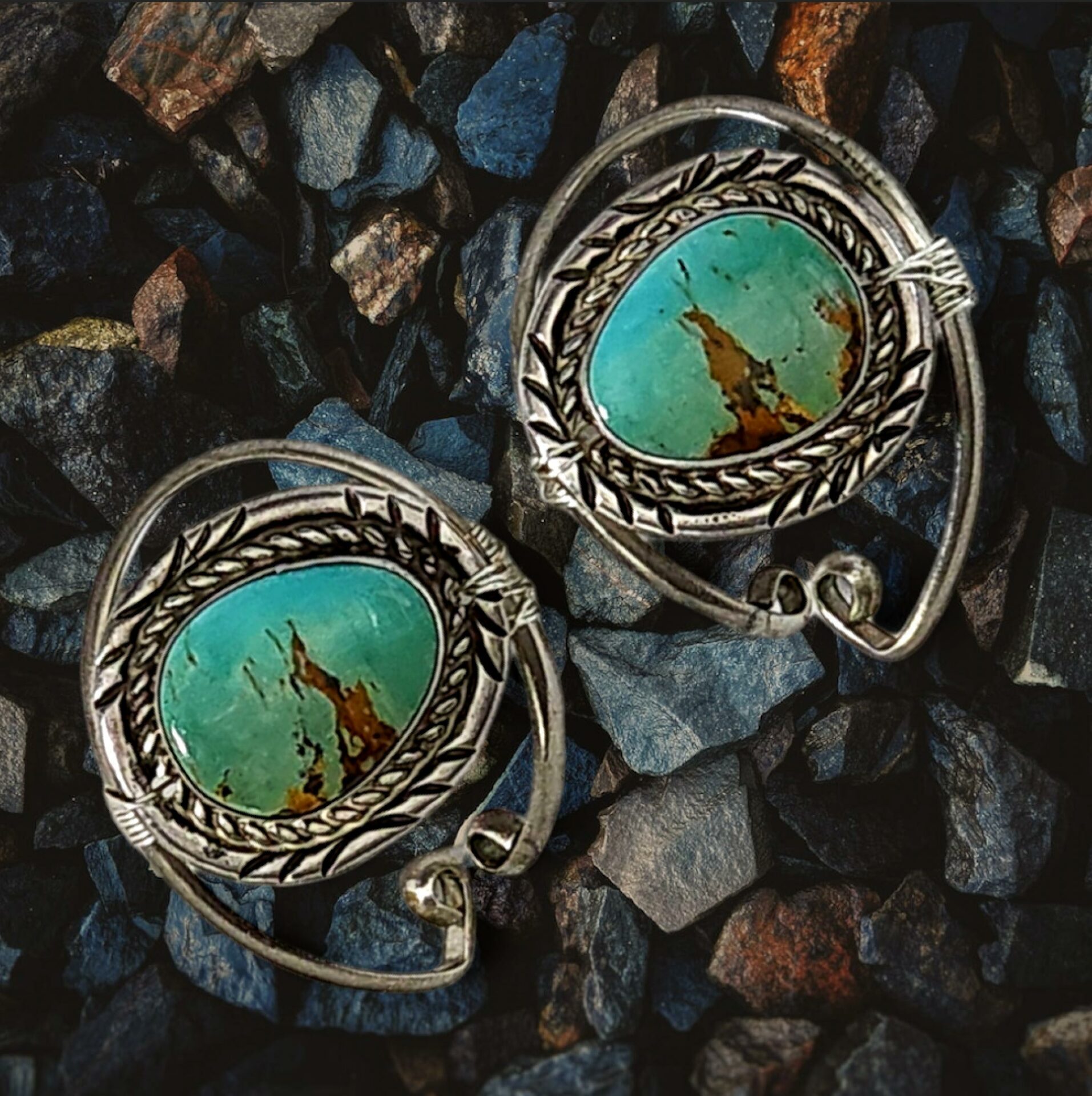 A pair of silver earrings with turquoise stones.