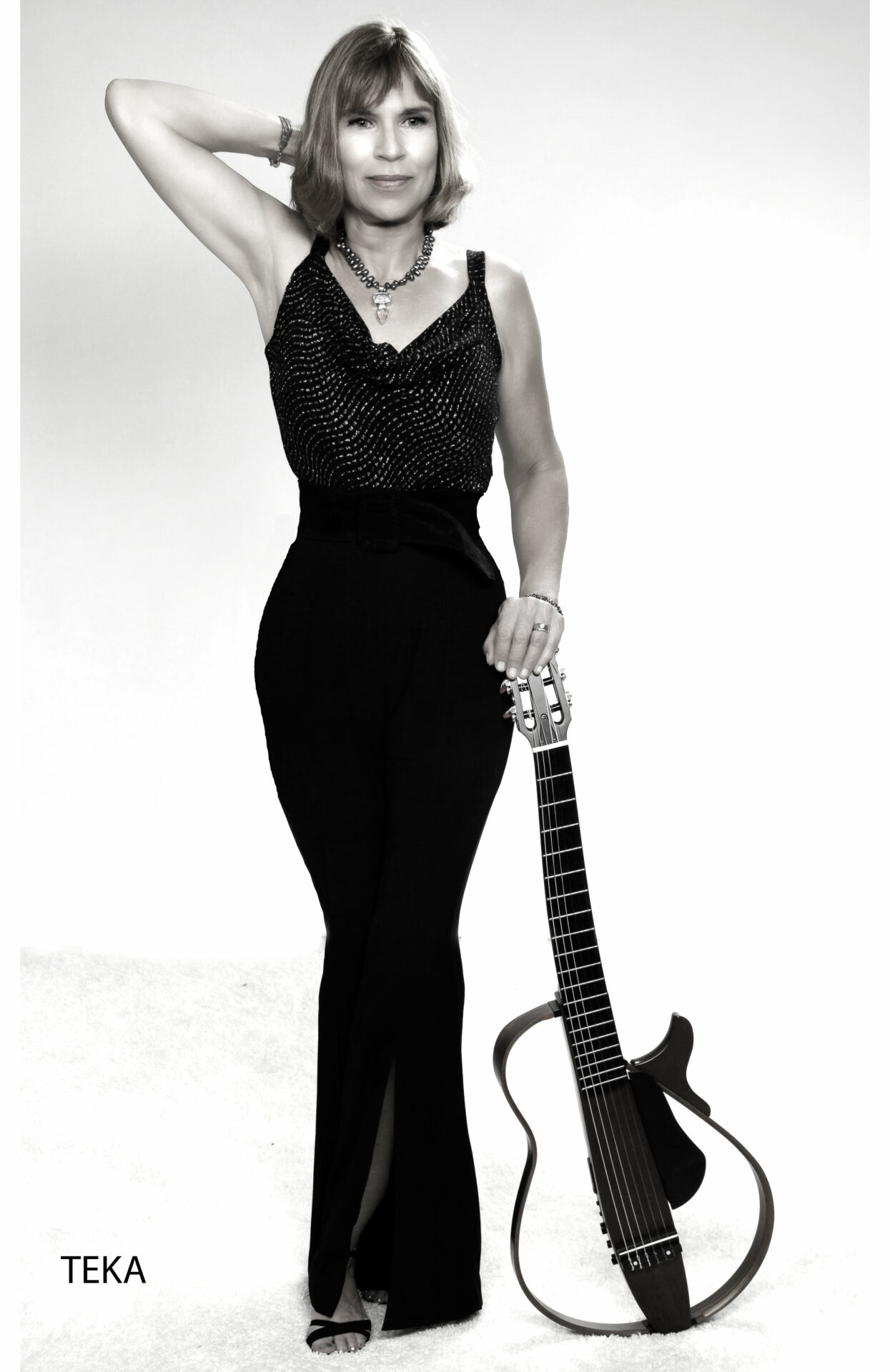 A black and white photo of a woman holding a guitar.