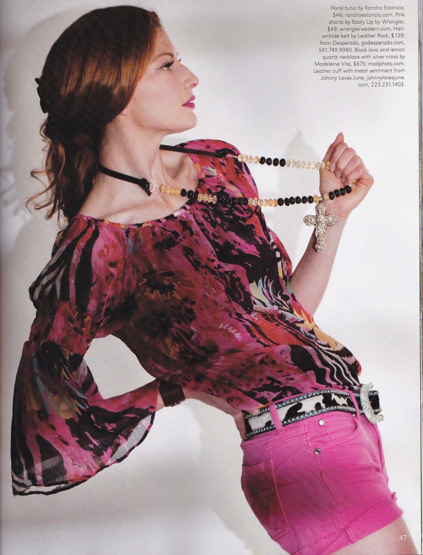 A woman in pink shorts and a necklace is posing in a magazine.